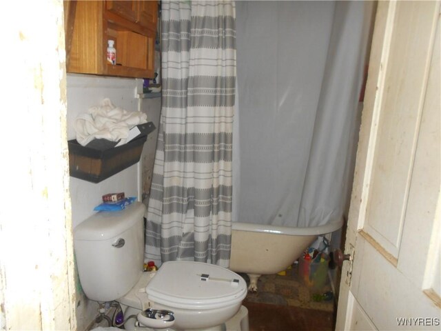 full bath with a shower with shower curtain, toilet, and a bathtub