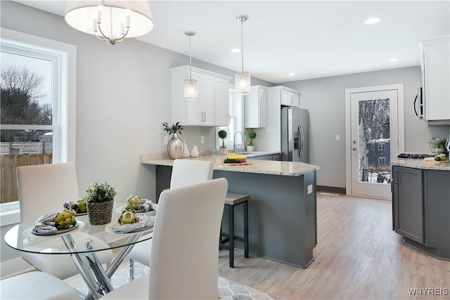 00 Beattie Ave, Lockport-Town, NY 14094 - kitchen with light wood-style flooring, a peninsula, light stone countertops, appliances with stainless steel finishes, and a sink