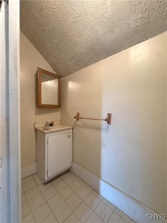 37754 County Route 194, Antwerp, NY 13608 - bathroom featuring vanity, baseboards, lofted ceiling, and a textured ceiling