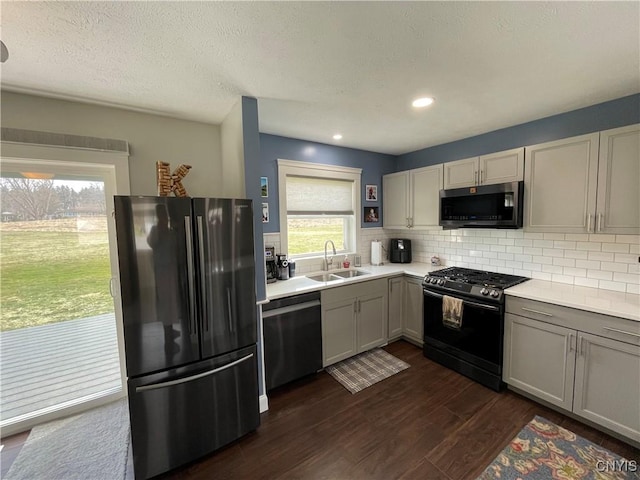 34 Salmon Meadow Ln, Richland, NY 13142 - kitchen with appliances with stainless steel finishes, a sink, light countertops, dark wood-style flooring, and backsplash