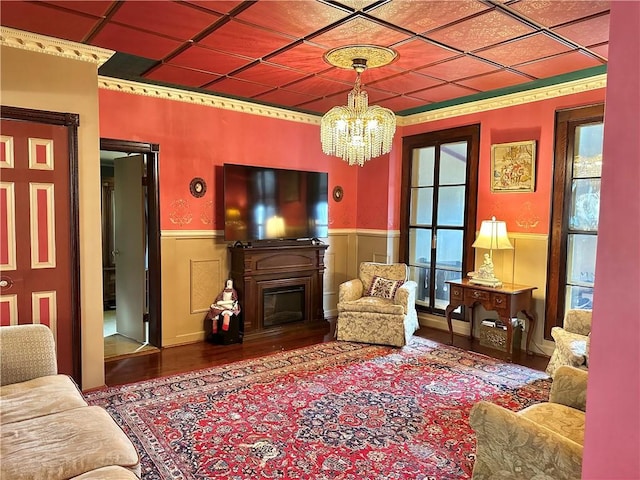 5166 State Highway 41, Smithville, NY 13778 - living area featuring wood finished floors, a notable chandelier, a glass covered fireplace, and wainscoting