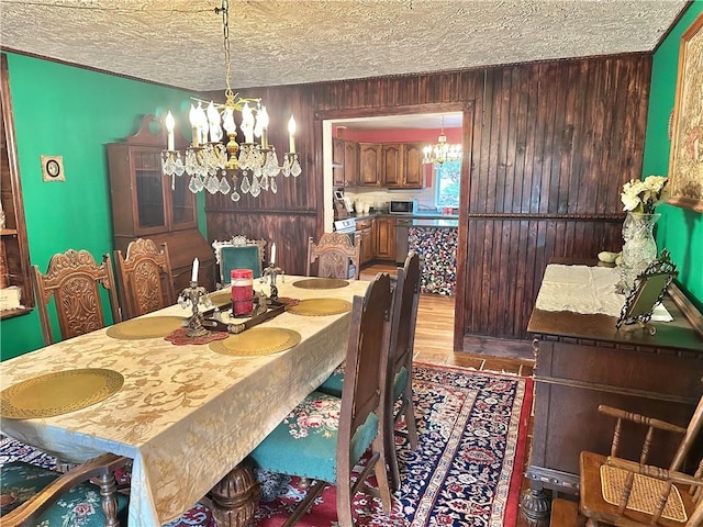 5166 State Highway 41, Smithville, NY 13778 - dining room with wooden walls, a chandelier, and a textured ceiling
