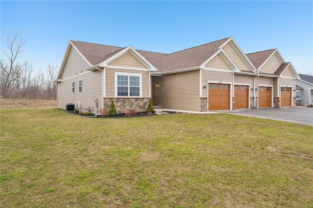 craftsman inspired home with central air condition unit, stone siding, a front lawn, an attached garage, and driveway