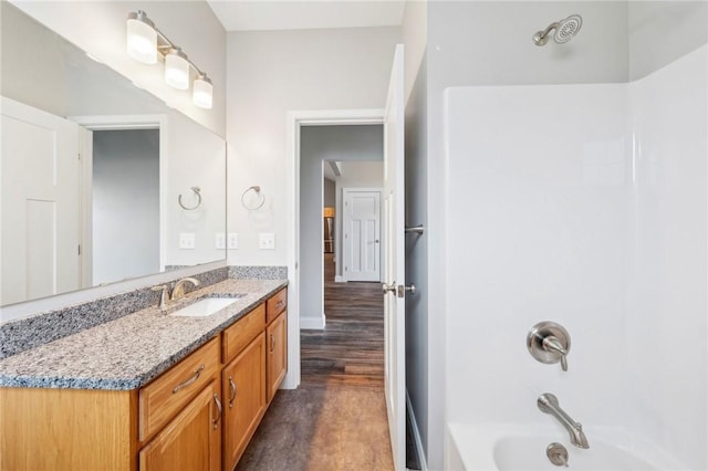 full bathroom featuring wood finished floors, vanity, and shower / tub combination