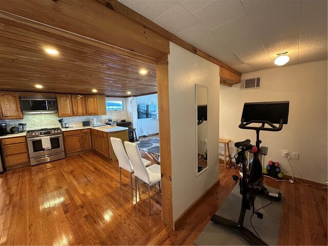 exercise area with light wood-style floors, a sink, and visible vents