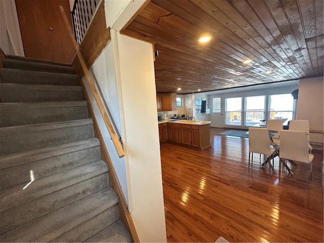 staircase with recessed lighting, wooden ceiling, and wood finished floors