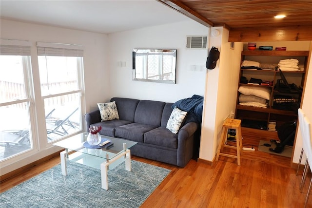 living room featuring visible vents, wood ceiling, and light wood-style flooring