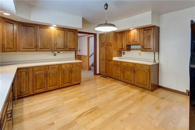 kitchen featuring light countertops, light wood finished floors, and brown cabinets