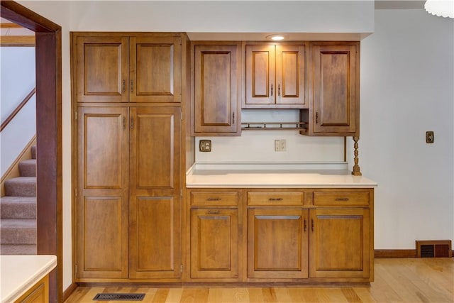 kitchen featuring visible vents, brown cabinetry, and light countertops