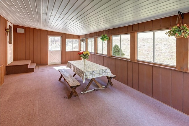 sunroom / solarium with wooden ceiling, wooden walls, and carpet