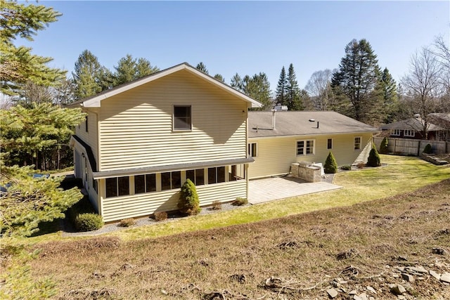 back of house featuring a lawn and a patio