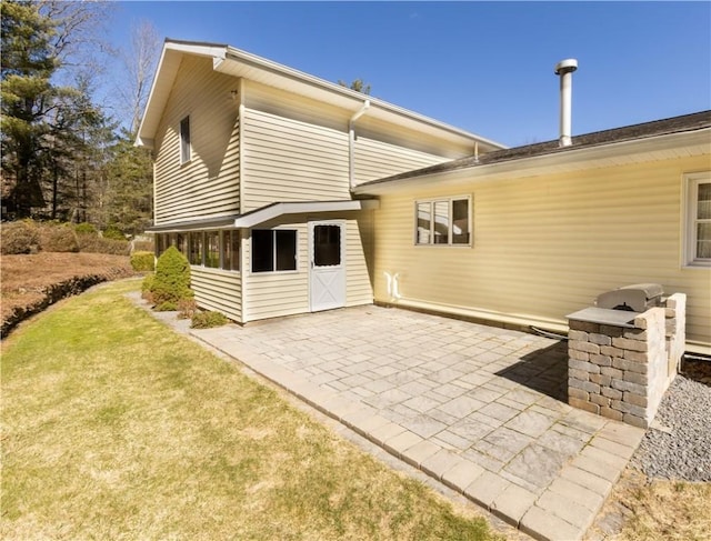rear view of house with a patio and a yard