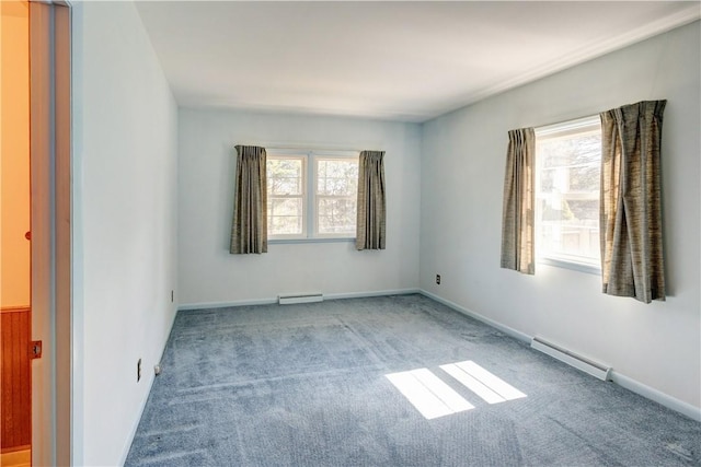 carpeted spare room with a wealth of natural light and baseboard heating