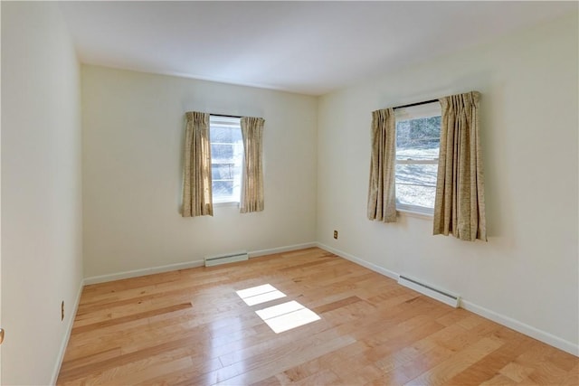 spare room featuring baseboards, wood finished floors, and baseboard heating