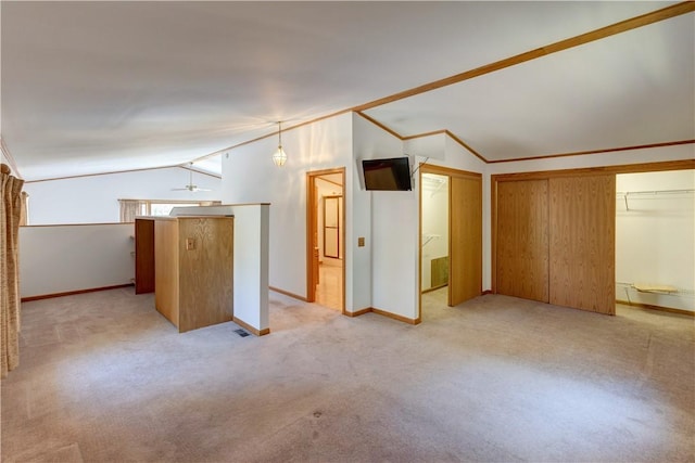 additional living space with light colored carpet, baseboards, vaulted ceiling, and ceiling fan