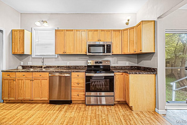 1002 N Madison St, Rome-Inside, NY 13440 - kitchen with dark stone counters, a sink, stainless steel appliances, and light wood-type flooring