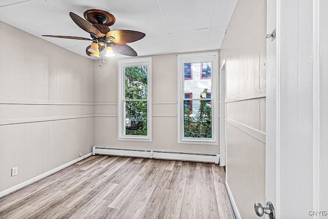 1002 N Madison St, Rome-Inside, NY 13440 - spare room featuring baseboards, ceiling fan, wood finished floors, and a baseboard heating unit