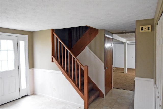 21 Algonquin Dr, Big Flats, NY 14845 - foyer with wainscoting, a textured ceiling, healthy amount of natural light, and stairway