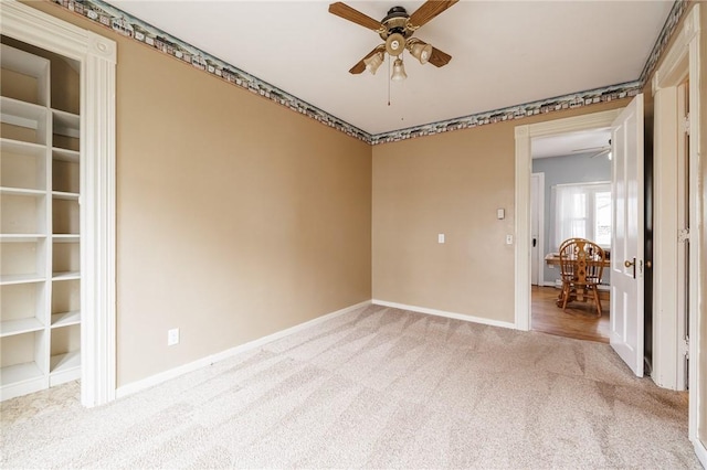 empty room with light carpet, baseboards, and ceiling fan