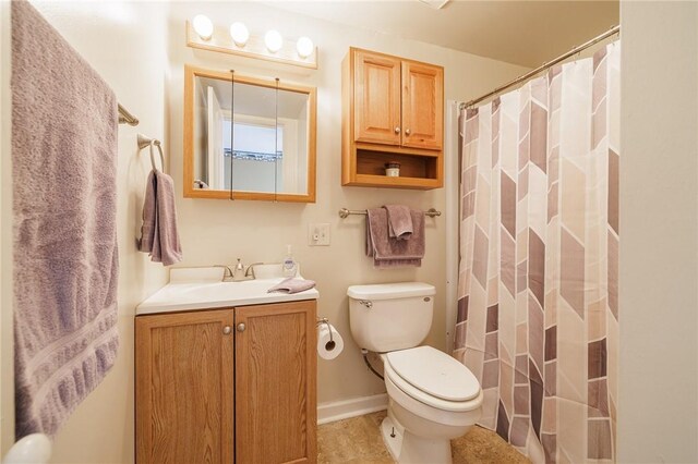 full bathroom with baseboards, a shower with shower curtain, toilet, and vanity