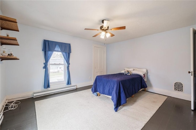 bedroom featuring baseboards, a baseboard heating unit, and hardwood / wood-style flooring