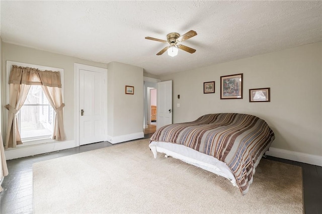 bedroom with baseboards, a ceiling fan, and a textured ceiling