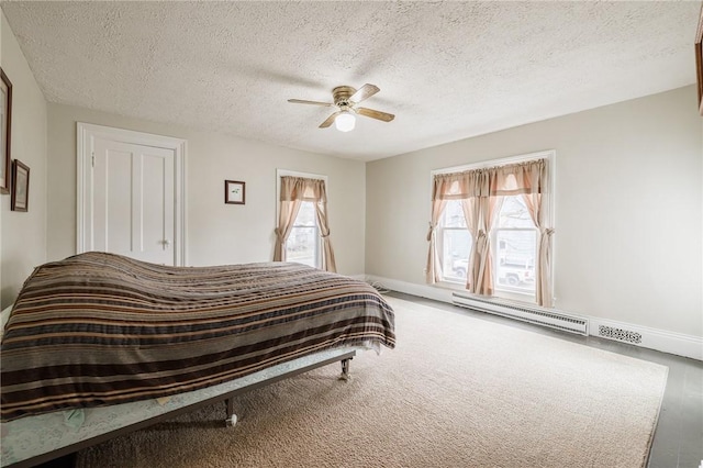 bedroom featuring a ceiling fan, baseboards, a baseboard heating unit, and a textured ceiling