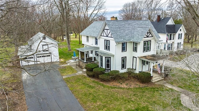 view of front of property with a garage, an outbuilding, a front lawn, and a chimney