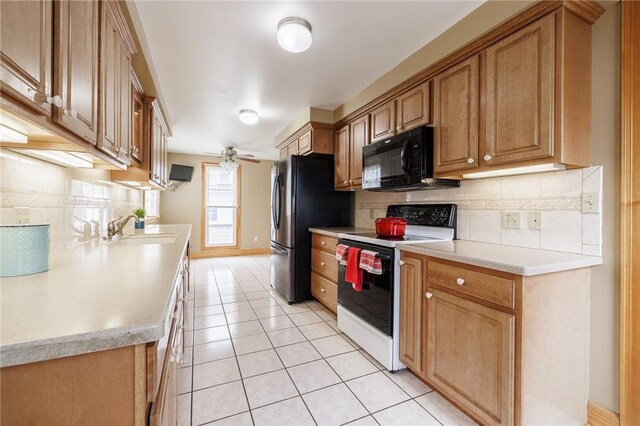 kitchen featuring light tile patterned flooring, backsplash, a sink, black microwave, and white electric range