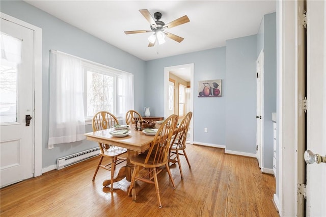 dining space with baseboards, light wood finished floors, ceiling fan, and a baseboard radiator