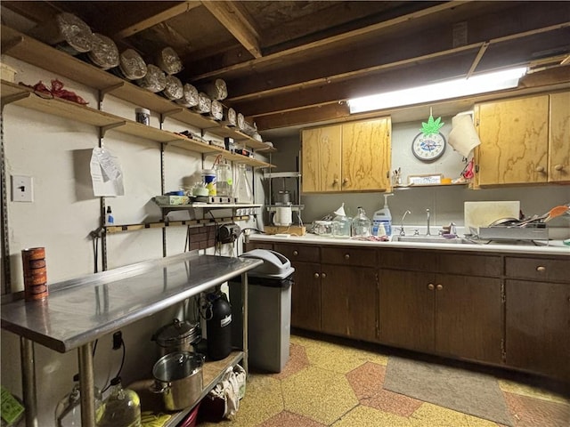kitchen with dark brown cabinetry, a sink, open shelves, and light floors