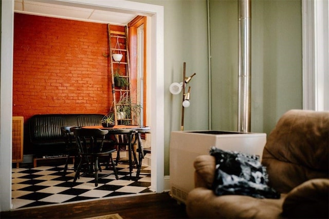 dining space with tile patterned floors and brick wall