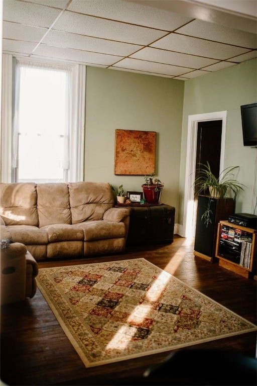 living area with dark wood finished floors and a paneled ceiling