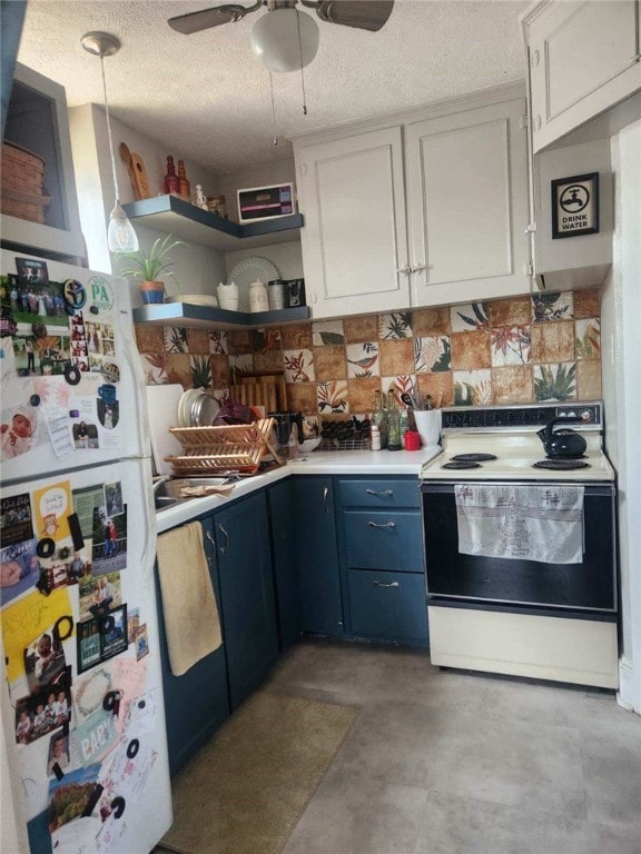 kitchen with blue cabinetry, light countertops, open shelves, freestanding refrigerator, and range with electric cooktop