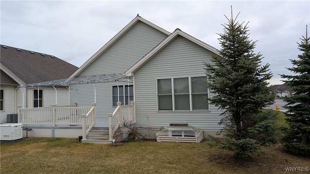back of property with central AC, a yard, and a wooden deck