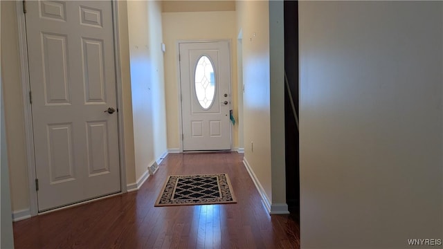 doorway to outside featuring baseboards and wood finished floors