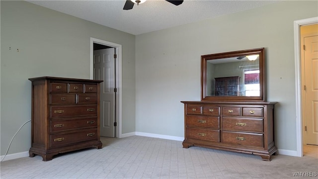 bedroom featuring a ceiling fan, light carpet, baseboards, and a textured ceiling
