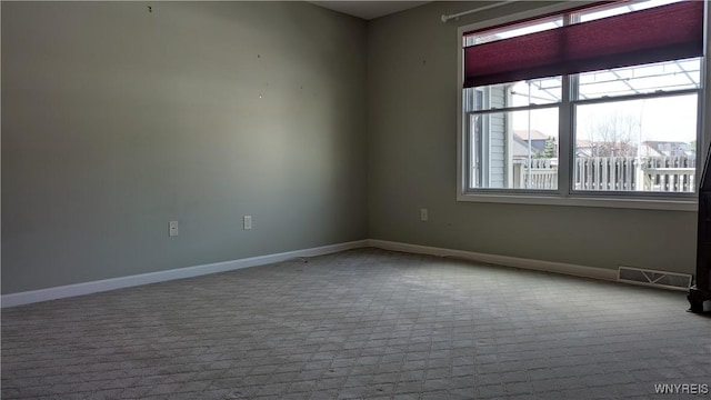 empty room featuring baseboards, visible vents, and carpet