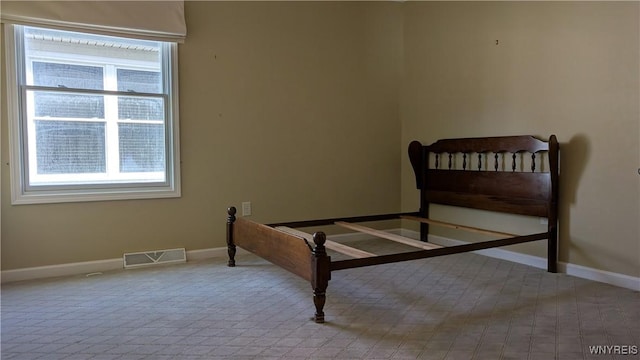 bedroom with baseboards, visible vents, and multiple windows