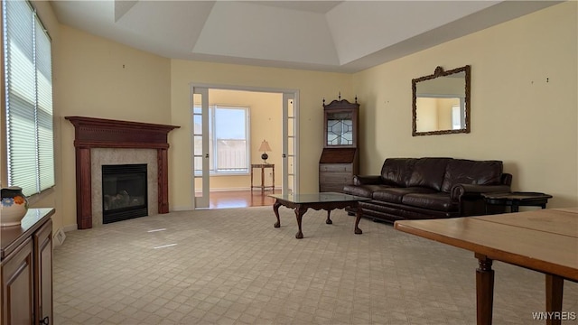 living room with a fireplace and a raised ceiling