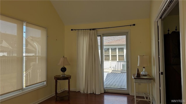 doorway to outside with baseboards, vaulted ceiling, and wood finished floors