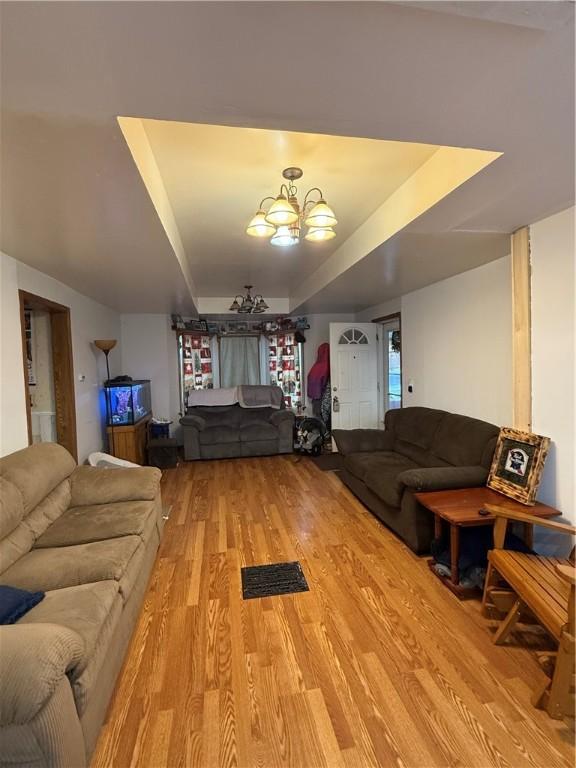 39 Steuben St, Addison, NY 14801 - living room with visible vents, a chandelier, light wood-style floors, and a raised ceiling