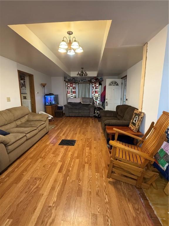 39 Steuben St, Addison, NY 14801 - living area featuring a notable chandelier, light wood-style floors, and a raised ceiling