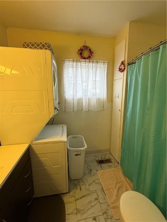 39 Steuben St, Addison, NY 14801 - bathroom with marble finish floor, a shower with shower curtain, toilet, and stacked washing maching and dryer