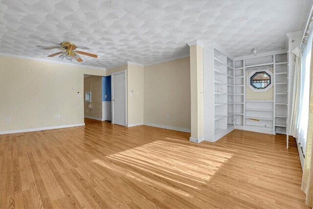 empty room featuring baseboards, ornamental molding, and a ceiling fan