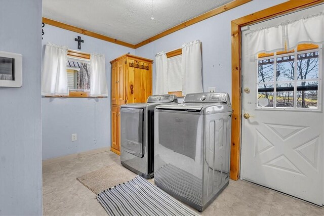 washroom with light tile patterned floors, plenty of natural light, baseboards, and washer and dryer