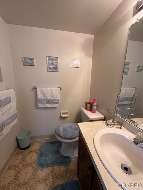 bathroom featuring tile patterned floors, vanity, toilet, and baseboards