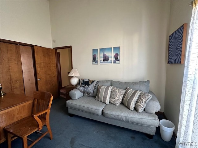 living area featuring a high ceiling and carpet