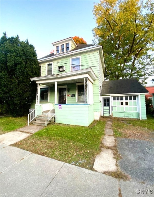 american foursquare style home with driveway, a porch, and a front yard