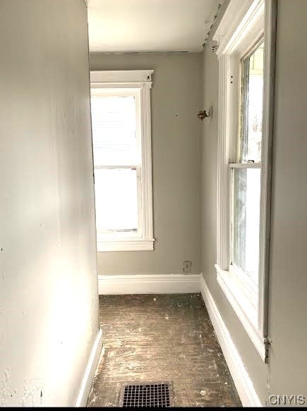 unfurnished room featuring visible vents, baseboards, and a wealth of natural light